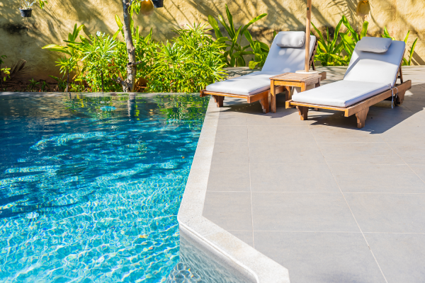 Constructor Piscinas Alicante con diseño moderno de piscina exterior y zona de descanso